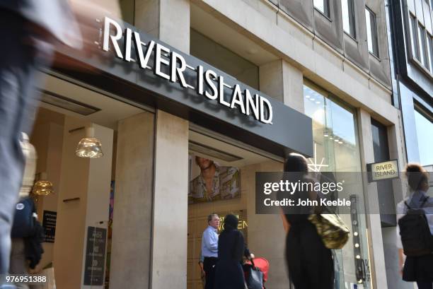 Shoppers walk past the River Island fashion retail shop entrance on Oxford Street on June 11, 2018 in London, England.