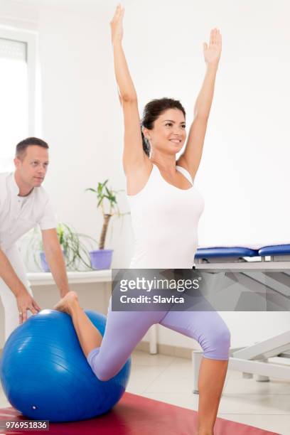 lächelnde frau auf physikalische therapie - sportmedizin happy stock-fotos und bilder