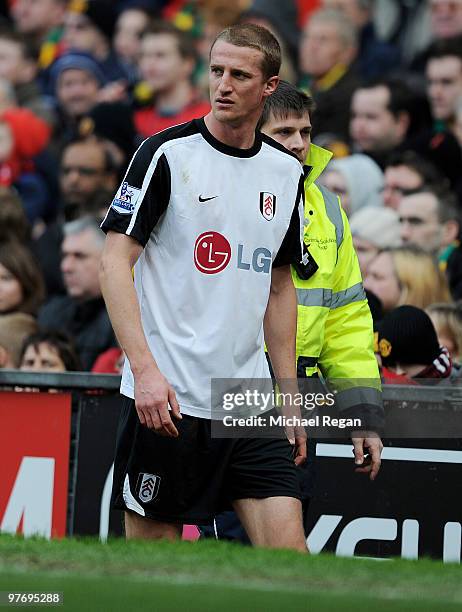 Brede Hangeland of Fulham goes off injured during the Barclays Premier League match between Manchester United and Fulham at Old Trafford on March 14,...