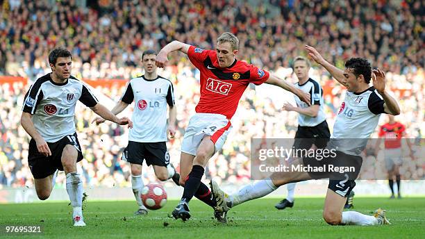 Darren Fletcher of Manchester United is challenged by Aaron Hughes and Stephen Kelly of Fulham during the Barclays Premier League match between...