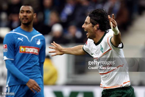 Claudio Pizarro of Bremen celebrates his team's first goal as Marvin Compper of Hoffenheim reacts during the Bundesliga match between 1899 Hoffenheim...