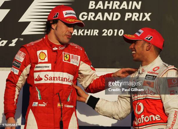 Race winner Fernando Alonso of Spain and Ferrari is congratulated by third placed Lewis Hamilton of Great Britain and McLaren Mercedes on the podium...