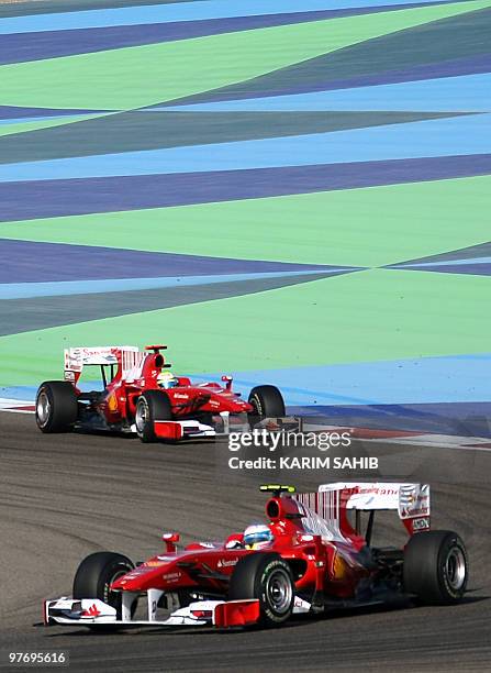 Ferrari's Spanish driver Fernando Alonso drives ahead of Ferrari's Brazilian driver Felipe Massa at the Bahrain international circuit on March 14,...