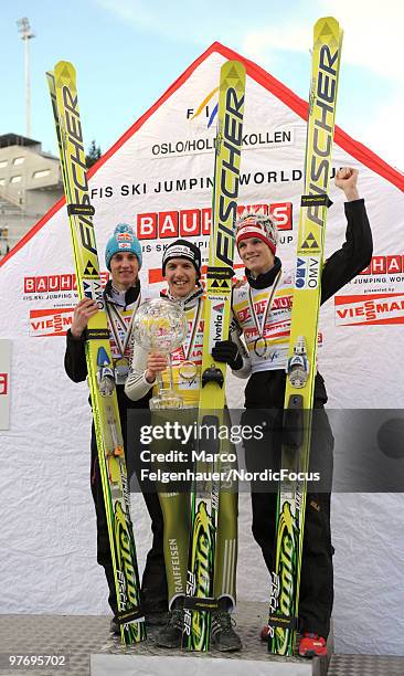 Gregor Schlierenzauer of Austria, Simon Ammann of Switzerland and Thomas Morgenstern of Austria celebrate the overall World Cup after the Ski Jumping...