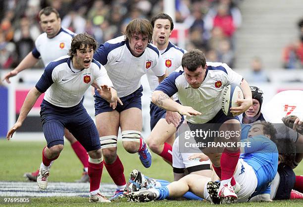 France's prop Thomas Domingo runs with the ball in front of teammates Alexis palisson and Julien Pierre during the Six Nations tournament rugby union...