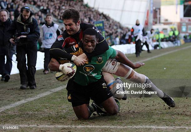 Brian Mujati of Northampton dives over to score a try despite being held by Ernst Joubert during the LV=Anglo Welsh Cup Semi Final between...