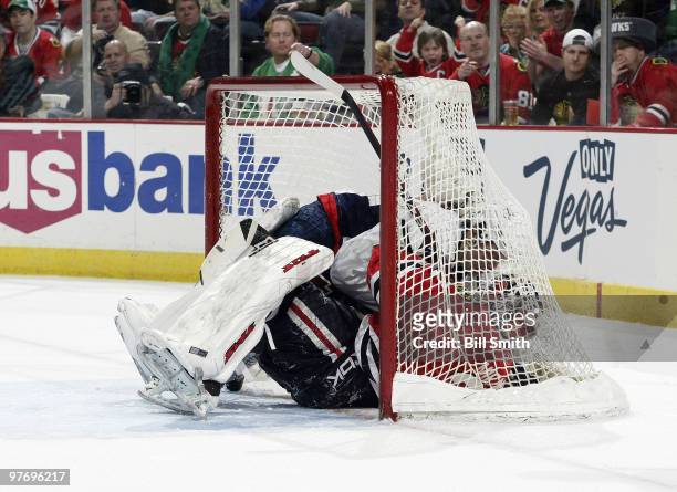 Alexander Semin of the Washington Capitals lands in the net with goalie Antti Niemi of the Chicago Blackhawks on March 14, 2010 at the United Center...