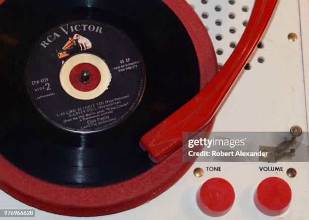 Vintage 1960s record player and 45 rpm Elvis Presley record for sale in an antique shop.