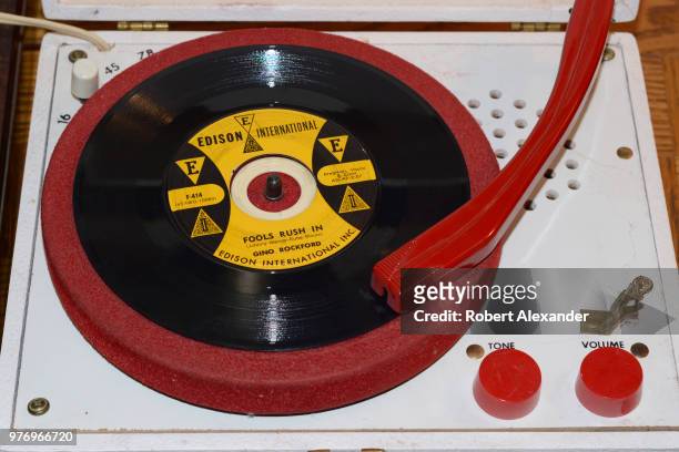 Vintage 1960s record player and 45 rpm Gino Rockford record for sale in an antique shop.