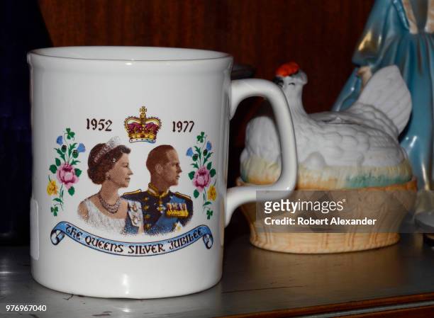 Silver Jubilee commemorative cup for sale in an antique shop features portraits of Great Britian's Queen Elizabeth II and her husband, Prince Philip,...