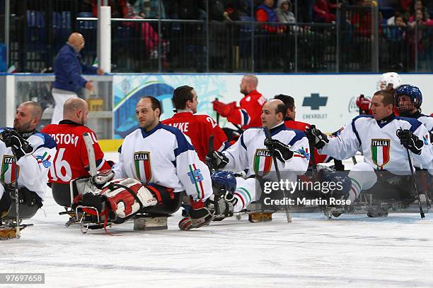 Team Italy shakes hands with team Norway after being defeated 2-1 during the Ice Sledge Hockey Preliminary Round Group B Game between Norway and...