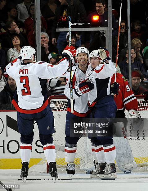 Nicklas Backstrom of the Washington Capitals celebrates with teammates Mike Knuble and Tom Poti after scoring the winning goal in overtime against...
