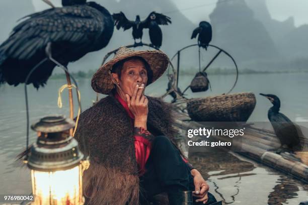 chinesische fischer qualmender zigarette auf bambus-floß - pfeife natur stock-fotos und bilder