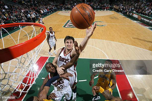 Luc Richard Mbah a Moute and Andrew Bogut of the Milwaukee Bucks reach for a rebound against Danny Granger of the Indiana Pacers on March 14, 2010 at...