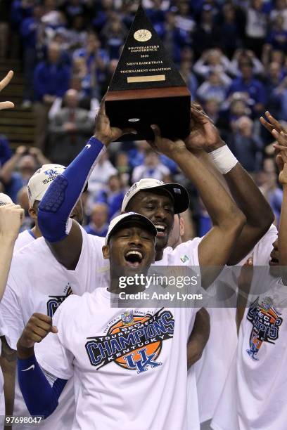 John Wall and Patrick Patterson of the Kentucky Wildcats celebrates with the trophy along with his teammates after they won 75-74 in overtime against...