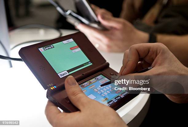 An attendee at the 2010 Game Developers Conference plays a game on the Nintendo DSi XL in San Francisco, California, U.S., on Thursday, March 11,...