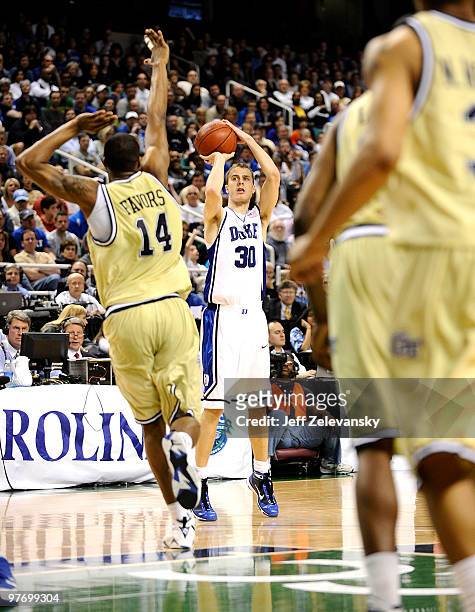 Jon Scheyer of the Duke Blue Devils shoots over Derrick Favors of the Georgia Tech Yellow Jackets in the championship game of the 2010 ACC Men's...