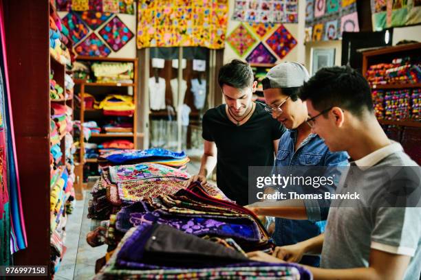 Three friends shopping for hand made goods in local shop while on vacation