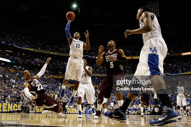 John Wall of the Kentucky Wildcats drives for a shot attempt against Barry Stewart and Romero Osby of the Mississippi State Bulldogs during the final...
