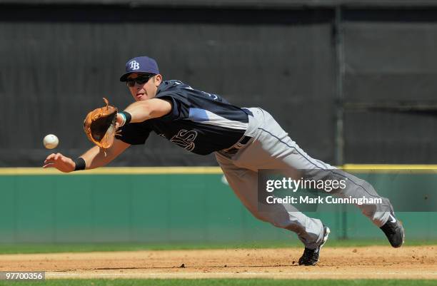 Evan Longoria of the Tampa Bay Rays dives for a baseball during the spring training game against the Detroit Tigers at Joker Marchant Stadium on...