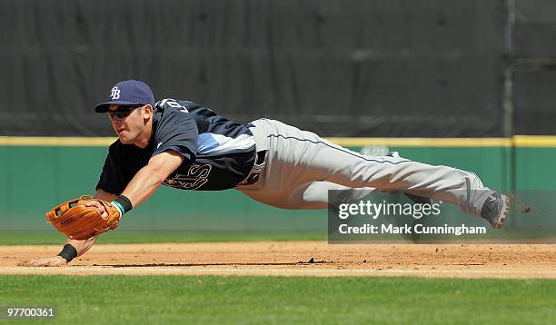 Evan Longoria of the Tampa Bay Rays dives for a baseball during the spring training game against the Detroit Tigers at Joker Marchant Stadium on...