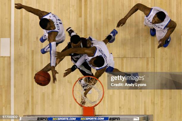 Dee Bost of the Mississippi State Bulldogs draws contact as he drives to the basket for a shot attempt against John Wall, Perry Stevenson and...