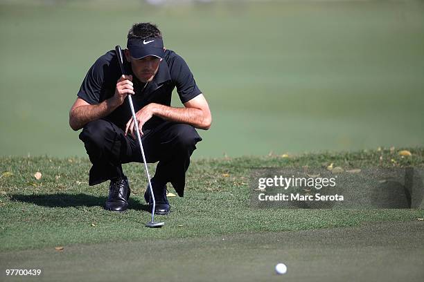 Charl Schwartzel of South Africa lines up a putt on the eighth hole during the final round of the 2010 WGC-CA Championship at the TPC Blue Monster at...