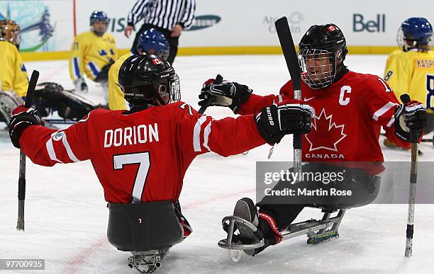 Marc Dorion of Canada celebrates his goal with teammate Jean Labonte during the second period of the Ice Sledge Hockey Preliminary Round Group B Game...