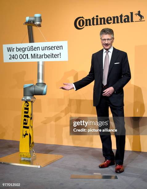 April 2018, Germany, Hannover: Elmar Degenhart, CEO of Continental AG, standing next to a Cobot robot, which is to be deployed in Continental...