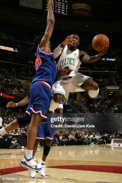 Nate Robinson of the Boston Celtics jumps high for the shot against Leon Powe of the Cleveland Cavaliers on March 14, 2010 at The Quicken Loans Arena...