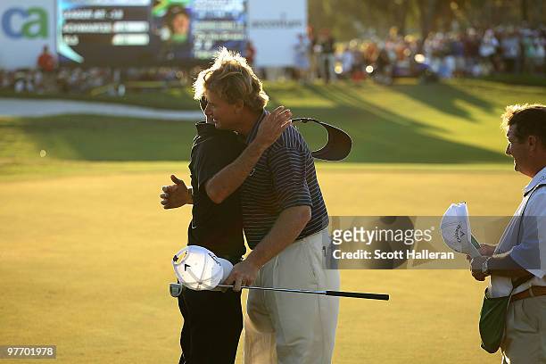 Ernie Els of South Africa hugs fellow South African Charl Schwartzel after winning the final round of the 2010 WGC-CA Championship at the TPC Blue...