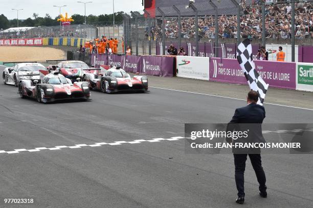 Toyota TS050 Hybrid LMP1 Japanese's driver Kazuki Nakajima crosses the finish line to win ahead Toyota TS050 Hybrid LMP1 Japan's driven by Kamui...