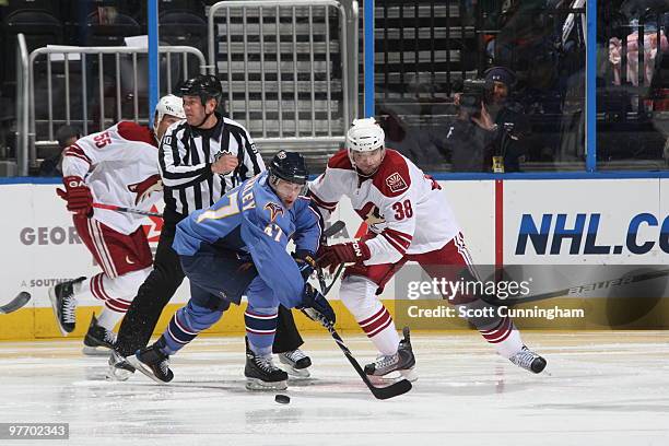 Rich Peverley of the Atlanta Thrashers battles for the puck against Vernon Fiddler of the Phoenix Coyotes at Philips Arena on March 14, 2010 in...