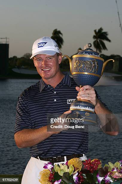 Ernie Els of South Africa lifts the Gene Sarazen Cup trophy on the 18th hole after winning the 2010 WGC-CA Championship at the TPC Blue Monster at...