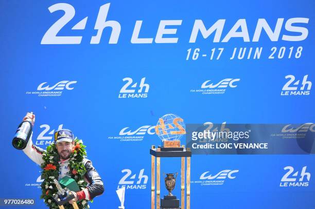 Toyota TS050 Hybrid LMP1's driver Spain's Fernando Alonso celebrates on the podium after winning the 86th edition of the 24h du Mans car endurance...