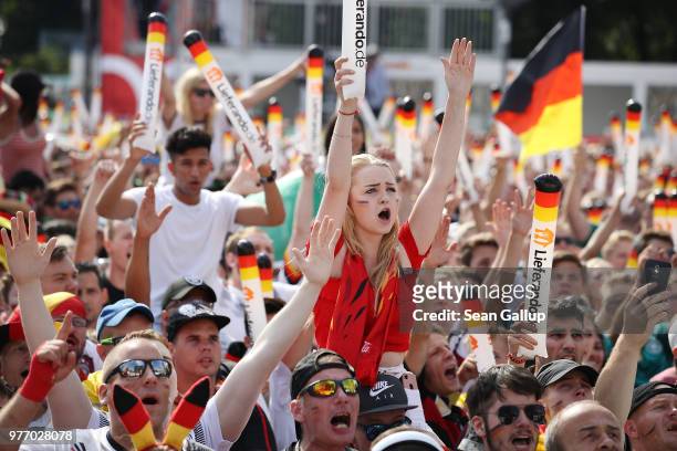 Fans wave German flags at the Fanmeile public viewing area prior to the Germany vs. Mexico 2018 FIFA World Cup match on June 17, 2018 in Berlin,...