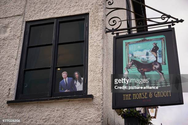 April 2018, Windsor, Great Britain: A photograph depicting Prince Harry and Meghan Markle hangs in the window of the pub "The Horse & Groom" across...