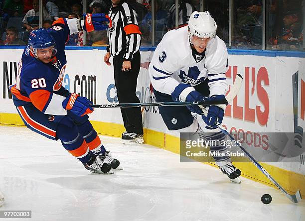 Dion Phaneuf of the Toronto Maple Leafs controls the puck in front of Sean Bergenheim of the New York Islanders on March 14, 2010 at Nassau Coliseum...
