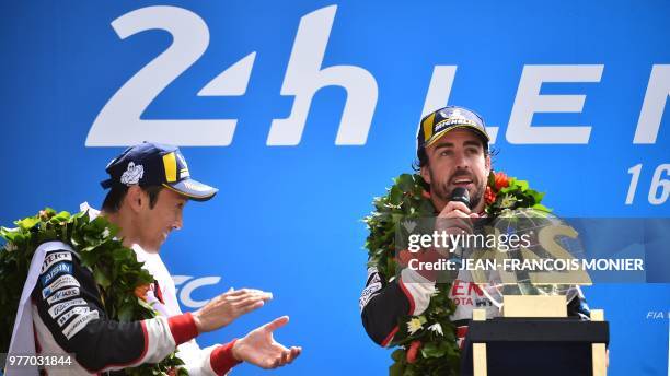 Spain's driver Fernando Alonso celebrates next his teammates Japanese's Kazuki Nakajima after winning the 86th Le Mans 24-hours endurance race, at...