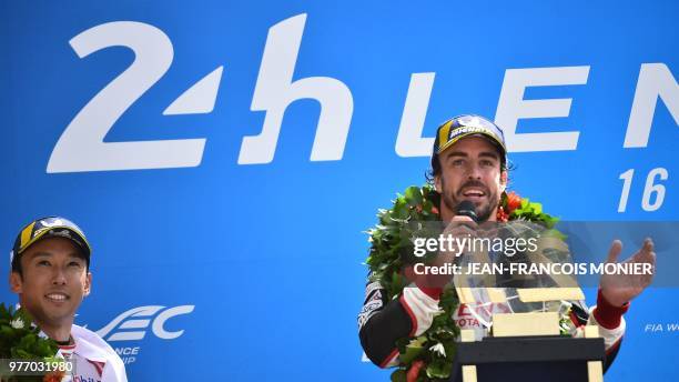 Spain's driver Fernando Alonso celebrates next his teammates Japanese's Kazuki Nakajima after winning the 86th Le Mans 24-hours endurance race, at...