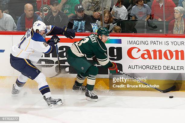 Marek Zidlicky of the Minnesota Wild skates with the puck while Patrik Berglund of the St. Louis Blues defends during the game at the Xcel Energy...