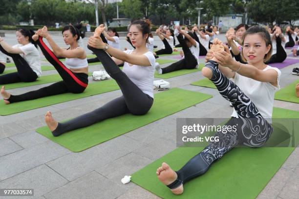 About a hundred people gather to do yoga at Zhuge Liang Square in the morning on June 17, 2018 in Xiangyang, Hubei Province of China. Yoga...