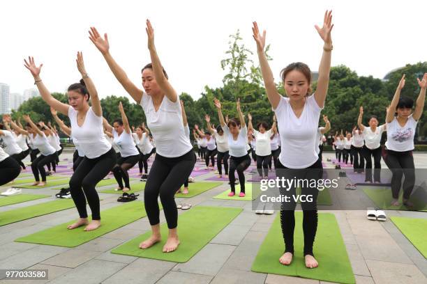 About a hundred people gather to do yoga at Zhuge Liang Square in the morning on June 17, 2018 in Xiangyang, Hubei Province of China. Yoga...