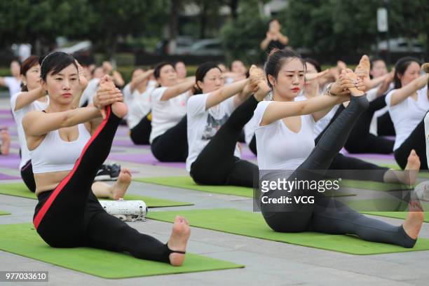 About a hundred people gather to do yoga at Zhuge Liang Square in the morning on June 17, 2018 in Xiangyang, Hubei Province of China. Yoga...