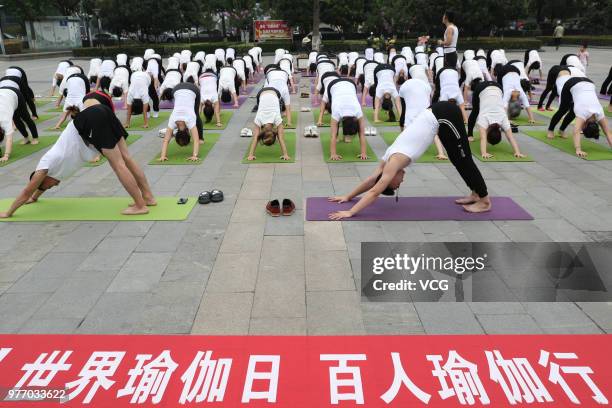 About a hundred people gather to do yoga at Zhuge Liang Square in the morning on June 17, 2018 in Xiangyang, Hubei Province of China. Yoga...