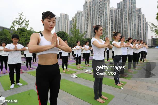 About a hundred people gather to do yoga at Zhuge Liang Square in the morning on June 17, 2018 in Xiangyang, Hubei Province of China. Yoga...