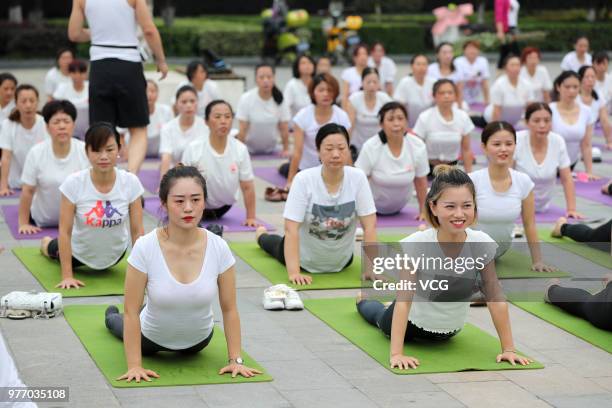 About a hundred people gather to do yoga at Zhuge Liang Square in the morning on June 17, 2018 in Xiangyang, Hubei Province of China. Yoga...