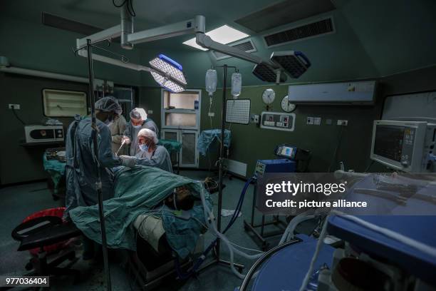British vascular surgeon John Wolfe, who was invited to Gaza by the International Committee of the Red Cross , performs a surgery for a wounded...