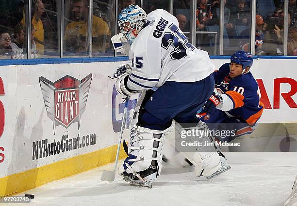 Jean-Sebastien Giguere of the Toronto Maple Leafs plays the puck against Richard Park of the New York Islanders on March 14, 2010 at Nassau Coliseum...