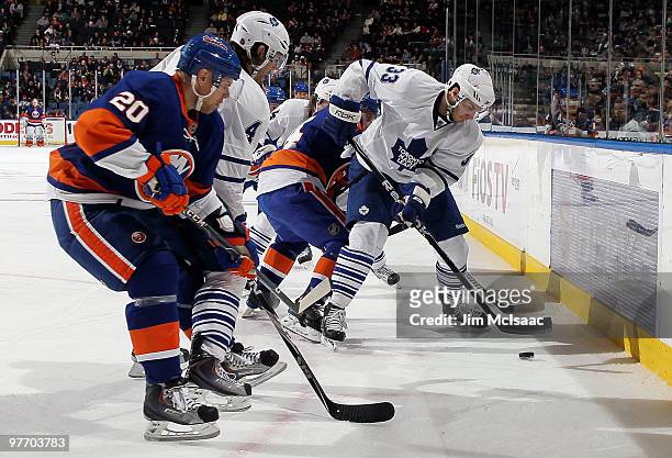 Luca Caputi of the Toronto Maple Leafs plays the puck against Sean Bergenheim on March 14, 2010 at Nassau Coliseum in Uniondale, New York.